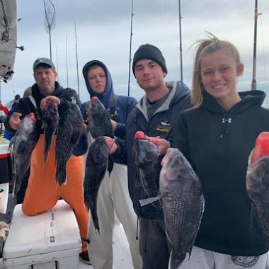 a group of people posing for a fish