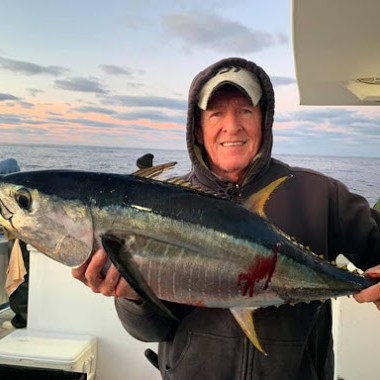 a person holding a fish posing for the camera