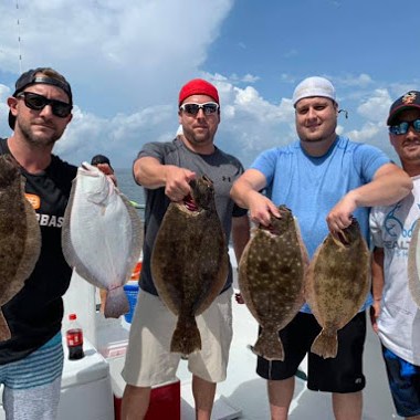 a group of people standing next to a man holding a fish