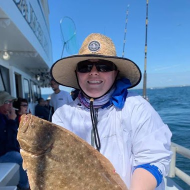 a person holding a fish on a boat