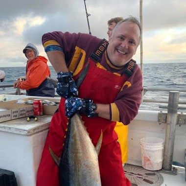 a man holding a fish on a boat