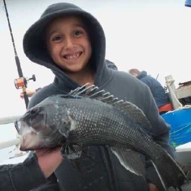 a young boy holding a fish