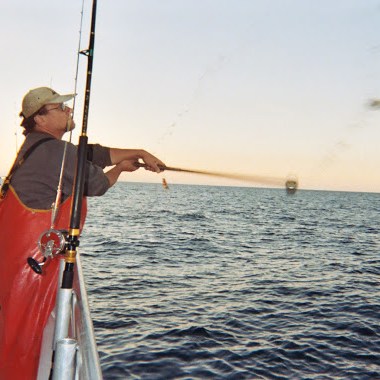 a man riding on the back of a boat in a body of water
