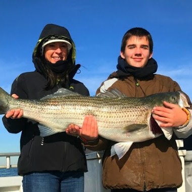 a person holding a fish posing for the camera
