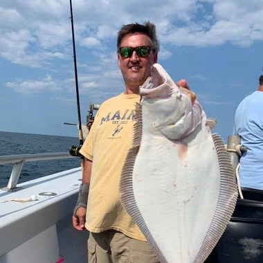 a person holding a fish on a boat