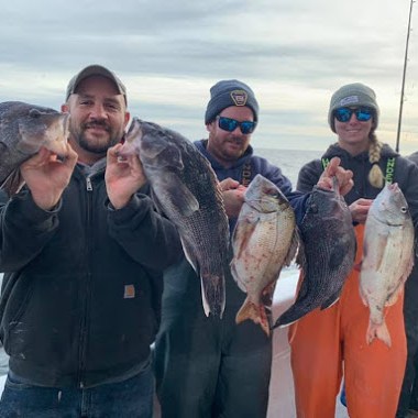 a group of people standing in front of a fish