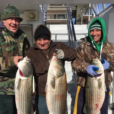 a group of people posing for a fish