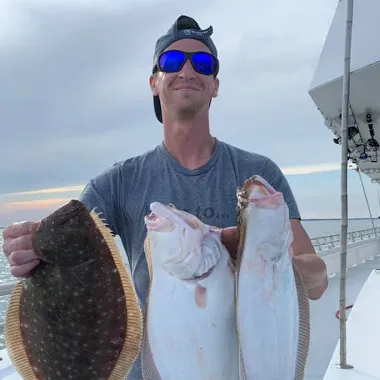a person holding a fish posing for the camera