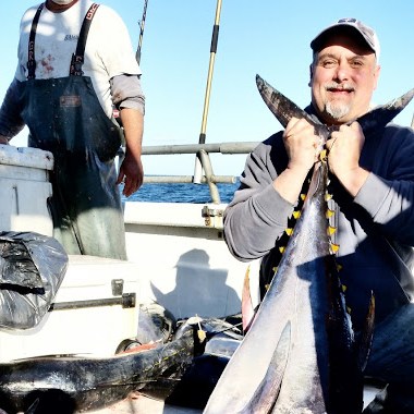 a person holding a fish on a boat