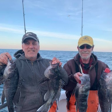 a group of people posing for a fish in the water