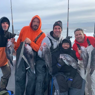 a group of people posing for a fish