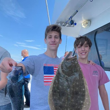 a person holding a fish posing for the camera