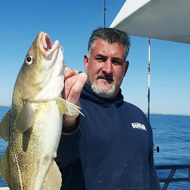 a man holding a fish in the water