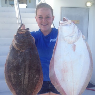 a person holding a fish posing for the camera