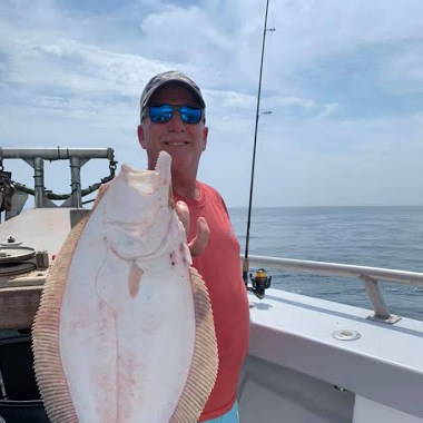 a person holding a fish on a boat