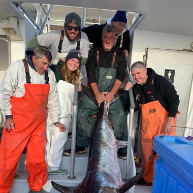 a group of people standing in front of a fish