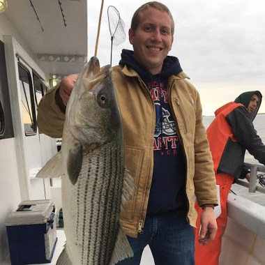 a person holding a fish posing for the camera