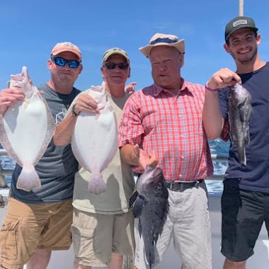 a group of people standing next to a person holding a fish