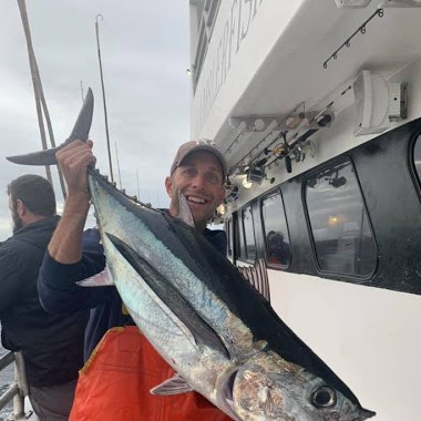 a person holding a fish on a boat