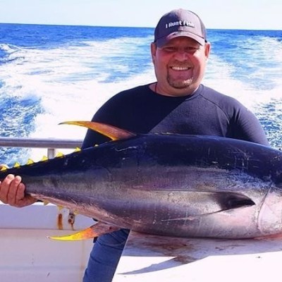 a man holding a fish in the water