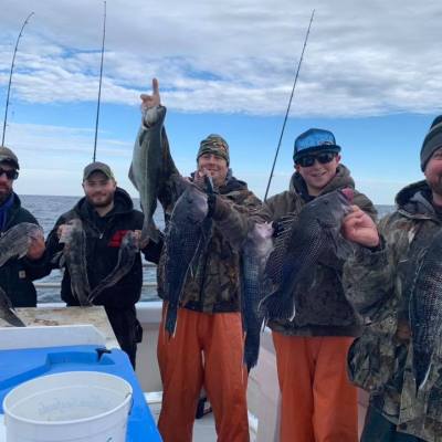 a group of people standing next to a person holding a fish