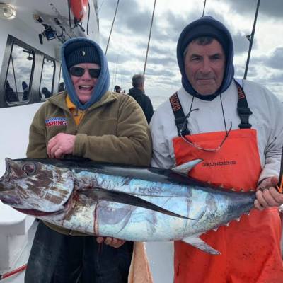 a person holding a fish on a boat